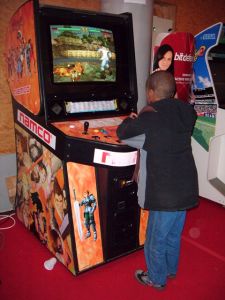 Petit garçon jouant à Soul Calibur 1 sur borne d'arcade